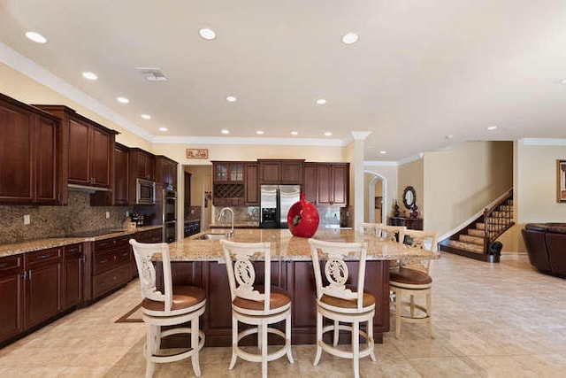 2646 Treanor Ter, Wellington, FL 33414 - kitchen with a spacious island, ornamental molding, appliances with stainless steel finishes, a kitchen breakfast bar, and a sink