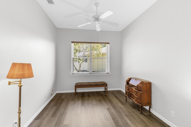 living area featuring ceiling fan, baseboards, and wood finished floors