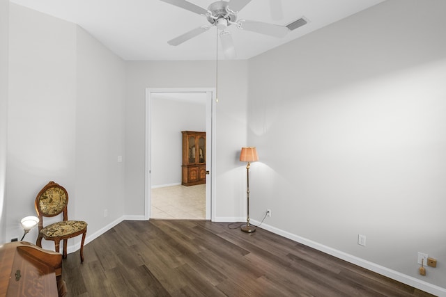 sitting room with ceiling fan, visible vents, baseboards, and wood finished floors