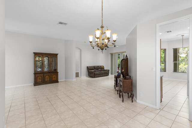 dining area with light tile patterned floors, visible vents, baseboards, and a notable chandelier