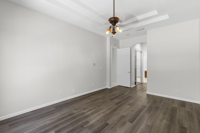 unfurnished room featuring visible vents, dark wood finished floors, arched walkways, baseboards, and ceiling fan