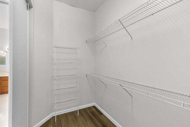 walk in closet with wood finished floors