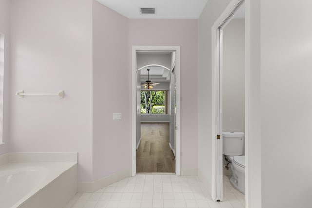 full bathroom with a bath, visible vents, ceiling fan, tile patterned floors, and toilet