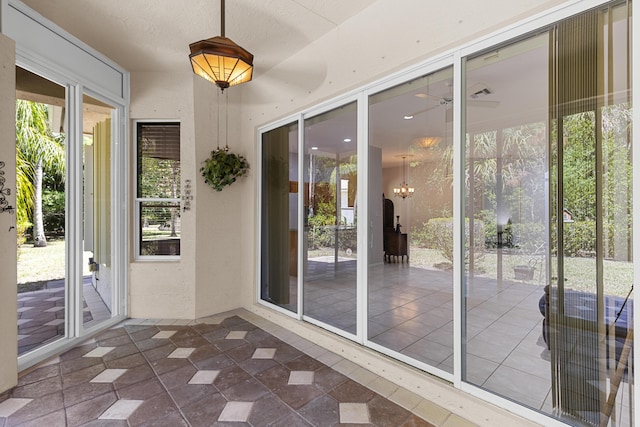 doorway to outside with a notable chandelier