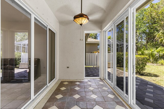 unfurnished sunroom with a textured wall
