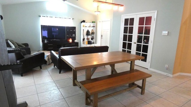 dining area featuring lofted ceiling, light tile patterned floors, french doors, and baseboards