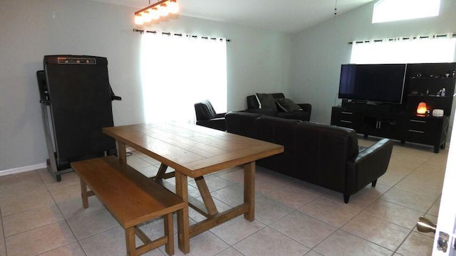dining space with vaulted ceiling and light tile patterned floors