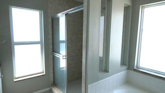 bathroom with a shower stall and a garden tub