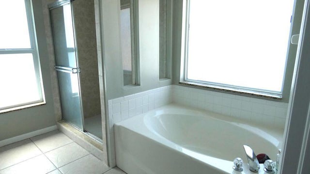 full bath featuring a wealth of natural light, a garden tub, a stall shower, and tile patterned floors