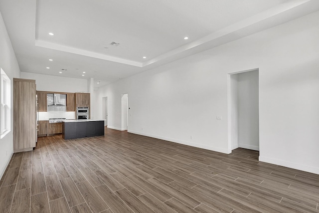 10064 Driftwood Way, Palm Beach Gardens, FL 33412 - unfurnished living room with recessed lighting, dark wood-type flooring, a raised ceiling, and baseboards