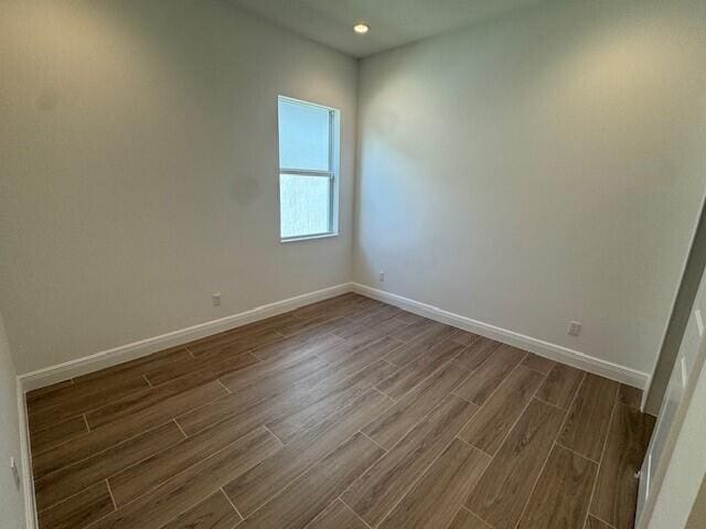 unfurnished room featuring recessed lighting, baseboards, and dark wood-style flooring