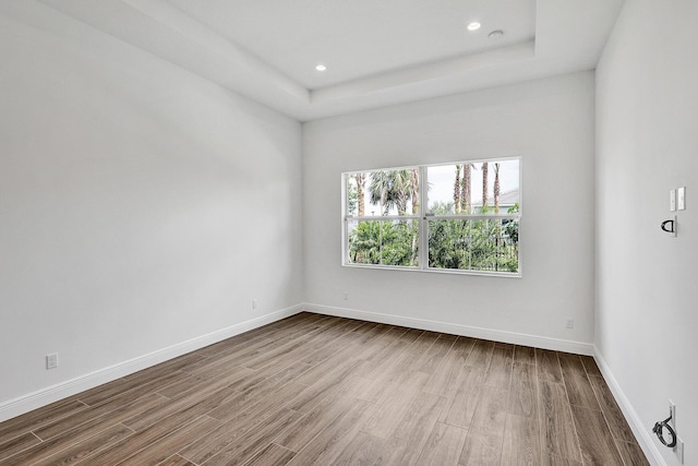 10064 Driftwood Way, Palm Beach Gardens, FL 33412 - unfurnished room featuring wood finished floors, baseboards, recessed lighting, and a tray ceiling
