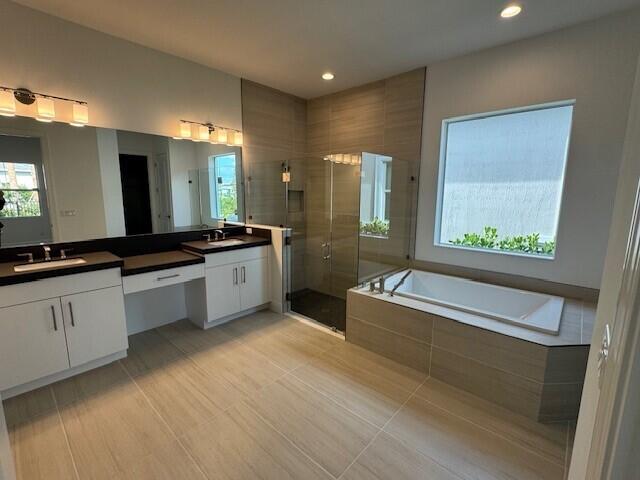full bathroom featuring a garden tub, plenty of natural light, a stall shower, and vanity