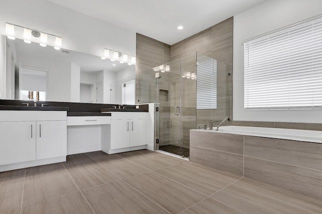 10064 Driftwood Way, Palm Beach Gardens, FL 33412 - full bath featuring double vanity, a shower stall, a bath, recessed lighting, and tile patterned flooring