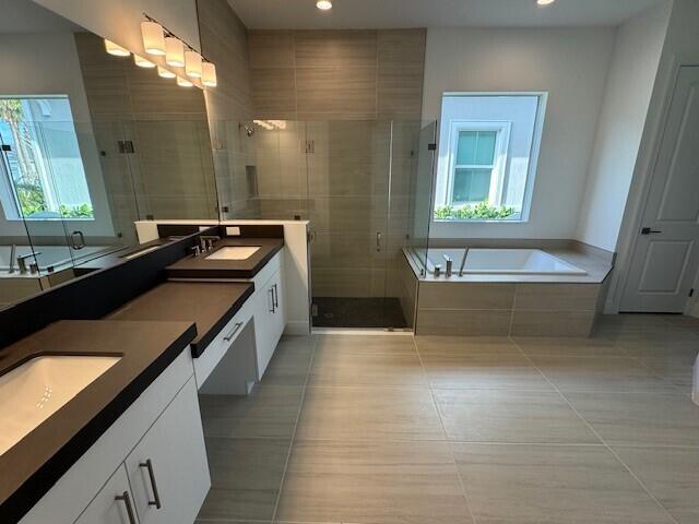 full bathroom with tile patterned flooring, vanity, recessed lighting, a bath, and a stall shower