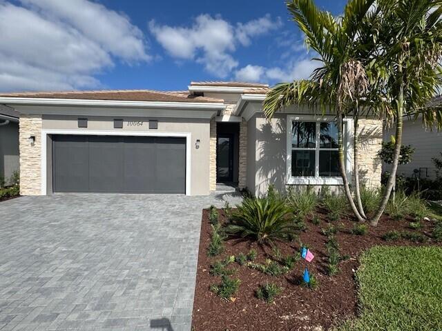 view of front of property with an attached garage, stucco siding, and decorative driveway