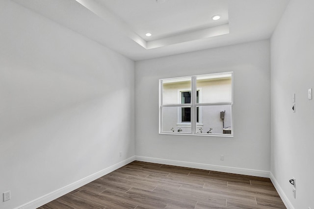 10064 Driftwood Way, Palm Beach Gardens, FL 33412 - spare room featuring dark wood finished floors, baseboards, recessed lighting, and a tray ceiling