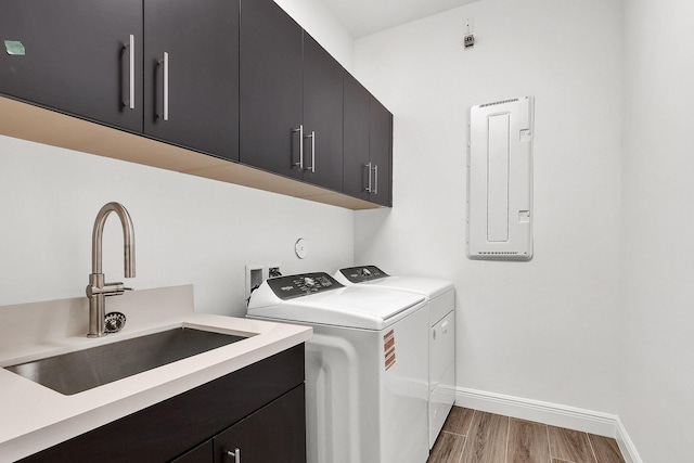 10064 Driftwood Way, Palm Beach Gardens, FL 33412 - laundry room with washer and clothes dryer, cabinet space, wood finished floors, baseboards, and electric panel