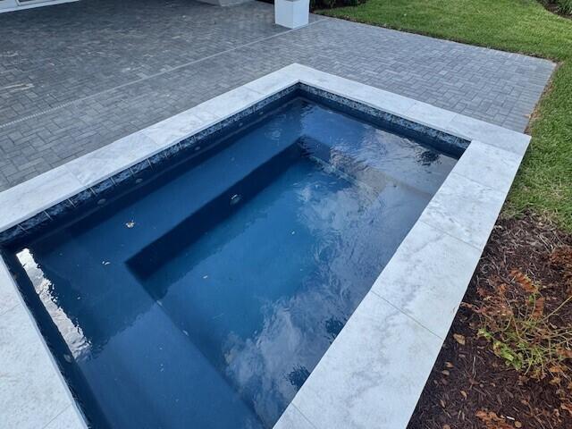 outdoor pool featuring a lawn