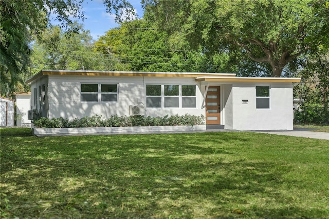 mid-century modern home featuring stucco siding and a front lawn
