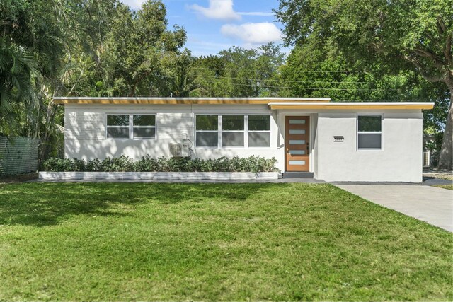 mid-century home featuring a front lawn and stucco siding