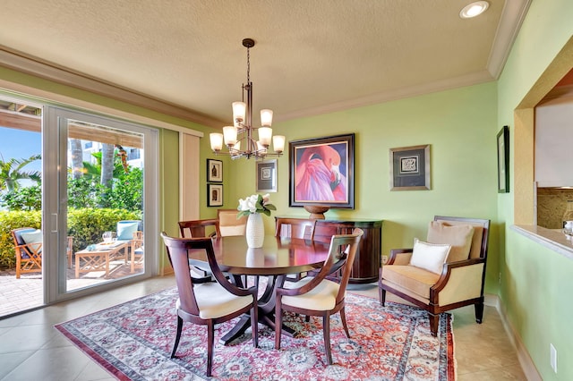 dining area with light tile patterned floors, a textured ceiling, an inviting chandelier, and ornamental molding