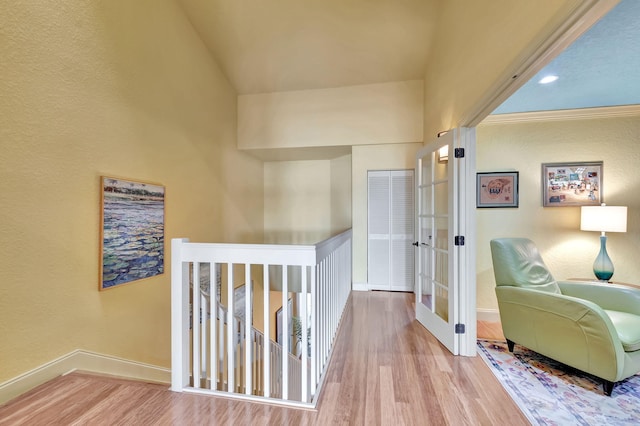 hallway with wood finished floors, an upstairs landing, french doors, and baseboards