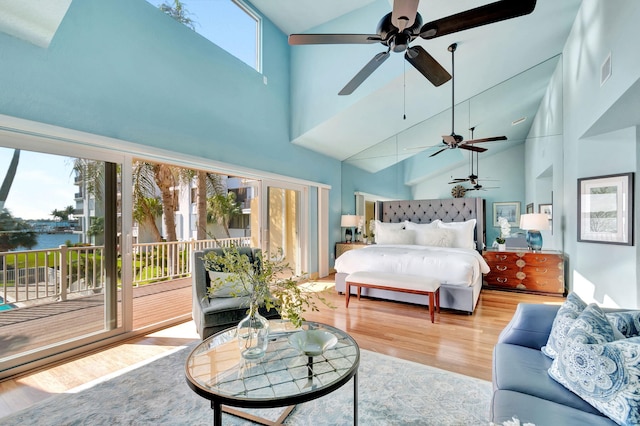 bedroom featuring wood finished floors, visible vents, ceiling fan, a water view, and access to outside