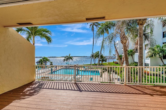 deck featuring a water view and a community pool