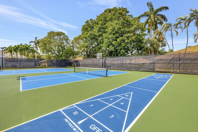 surrounding community with a tennis court and fence