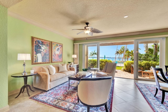 living room featuring light tile patterned floors, baseboards, ceiling fan, ornamental molding, and a textured ceiling