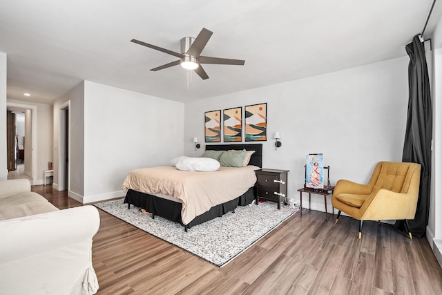 bedroom with ceiling fan, light wood finished floors, and baseboards