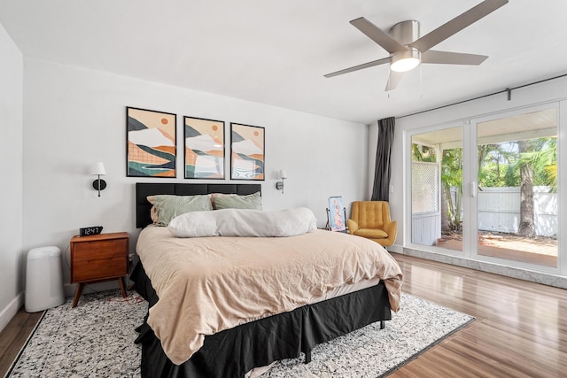 bedroom with access to exterior, ceiling fan, and wood finished floors