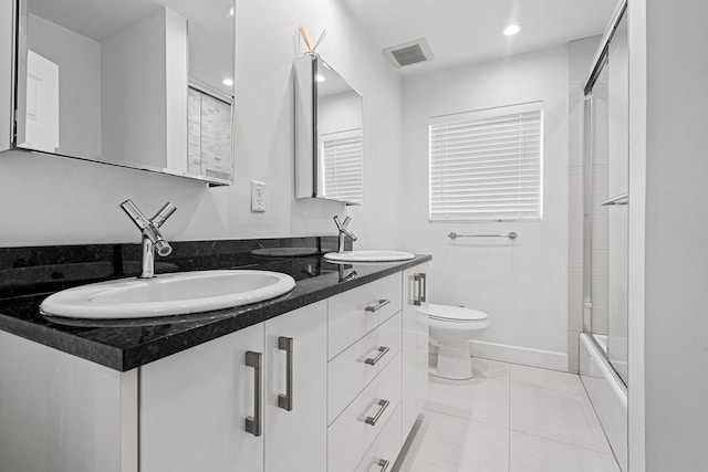 full bathroom with a sink, visible vents, toilet, and double vanity