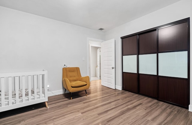 bedroom featuring light wood-type flooring, baseboards, and visible vents