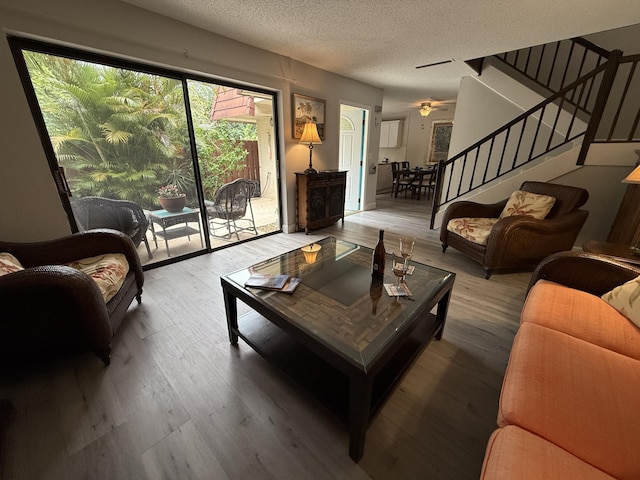 9407 S Ocean Dr Unit 1D, Jensen Beach, FL 34957 - living area featuring stairway, a textured ceiling, wood finished floors, and a ceiling fan