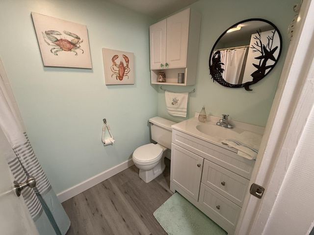 9407 S Ocean Dr Unit 1D, Jensen Beach, FL 34957 - full bathroom with wood finished floors, toilet, vanity, and baseboards