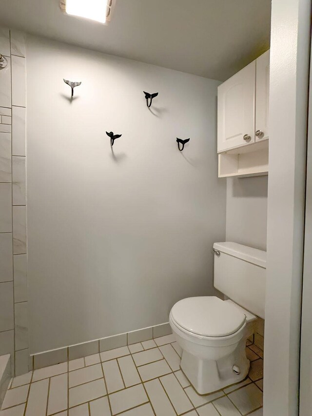 9407 S Ocean Dr Unit 1D, Jensen Beach, FL 34957 - bathroom featuring toilet, a shower, baseboards, and tile patterned flooring
