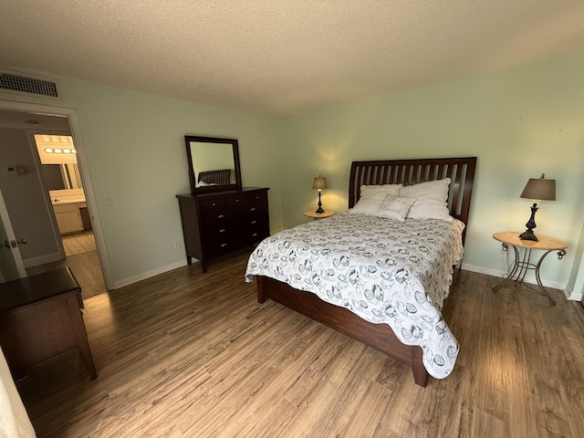 9407 S Ocean Dr Unit 1D, Jensen Beach, FL 34957 - bedroom featuring wood finished floors, a textured ceiling, and baseboards