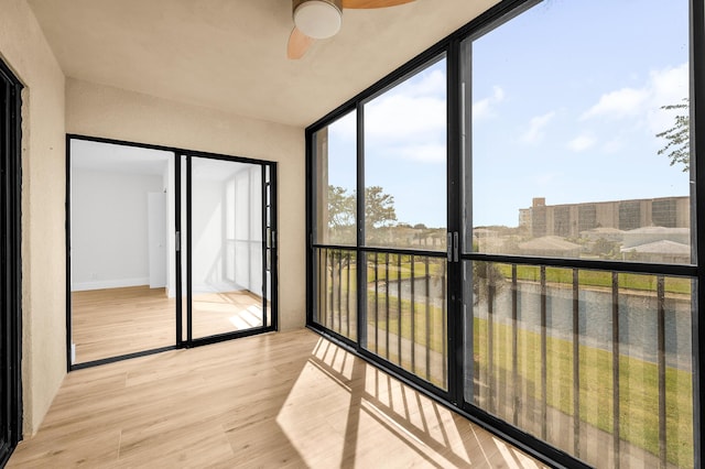 unfurnished sunroom featuring a ceiling fan