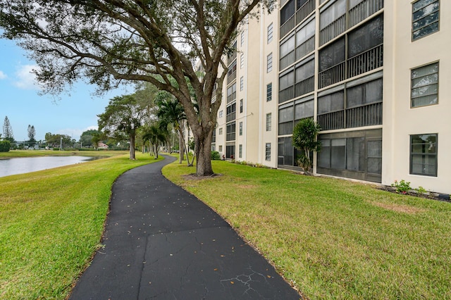view of community with a lawn and a water view