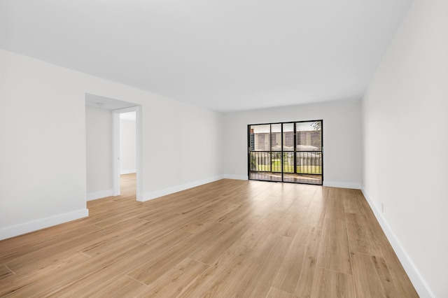 empty room featuring baseboards and light wood-style floors