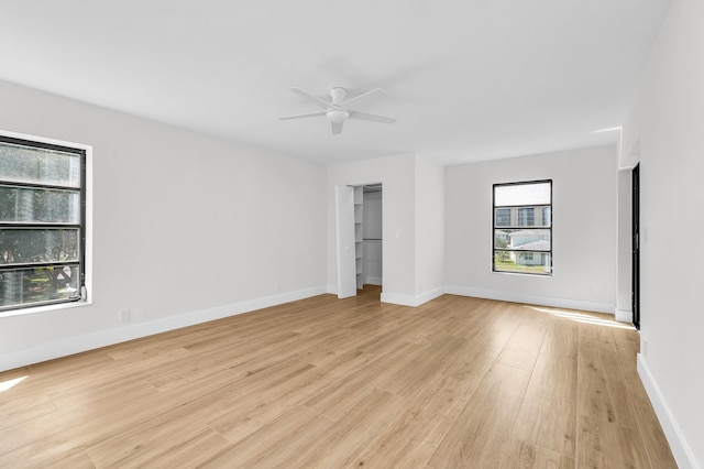 interior space featuring a ceiling fan, light wood-style floors, and baseboards