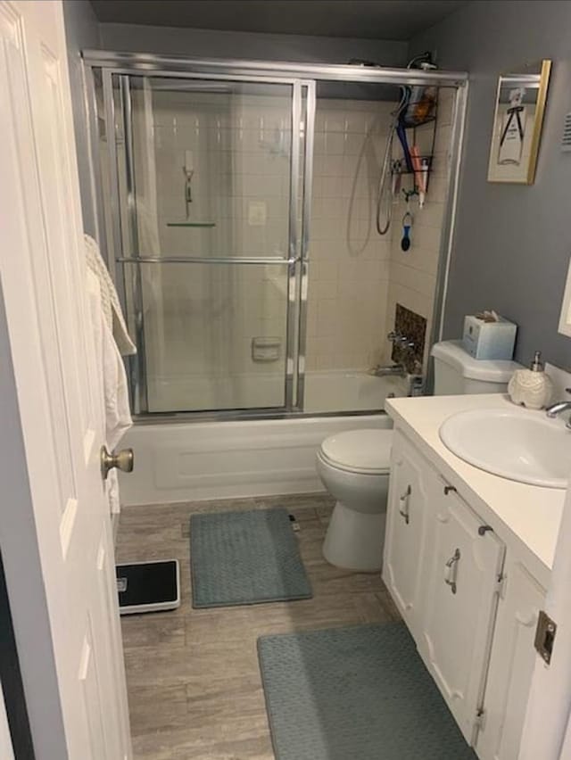 3113 S Ocean Dr Unit 301, Hallandale Beach, FL 33009 - bathroom with combined bath / shower with glass door, toilet, wood finished floors, and vanity