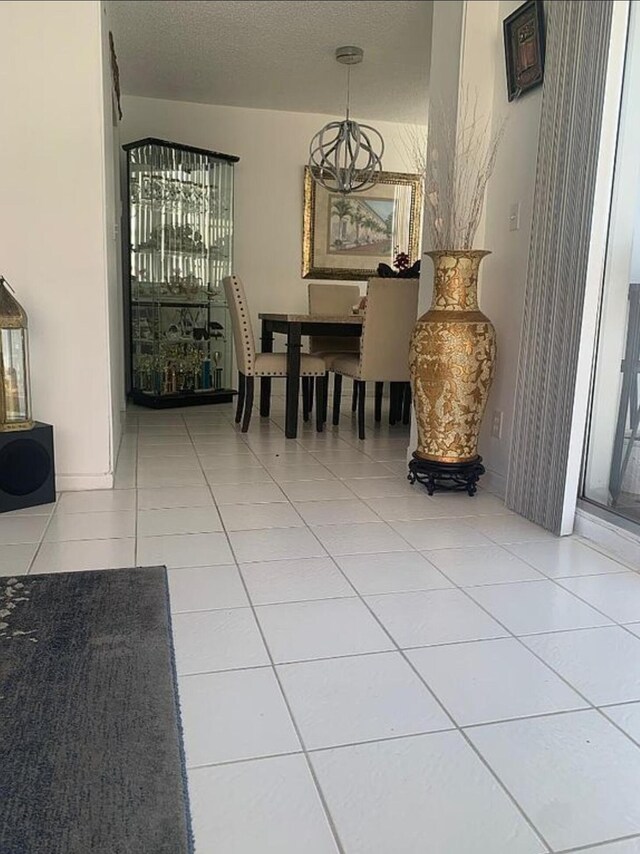 3113 S Ocean Dr Unit 301, Hallandale Beach, FL 33009 - tiled dining room featuring an inviting chandelier and a textured ceiling