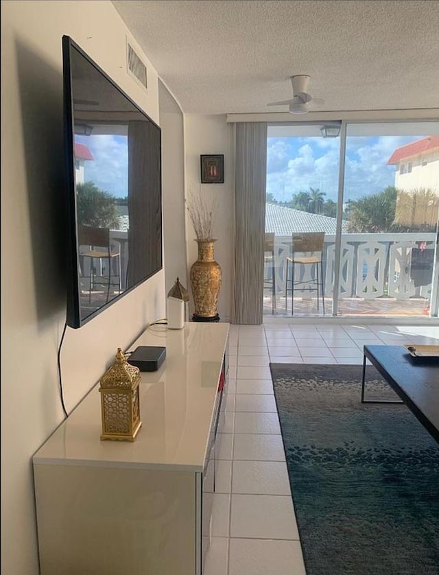 3113 S Ocean Dr Unit 301, Hallandale Beach, FL 33009 - interior space featuring light tile patterned floors, a healthy amount of sunlight, a textured ceiling, and a ceiling fan