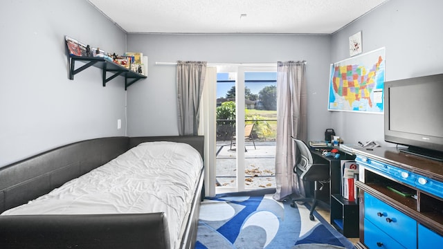 bedroom with access to outside and a textured ceiling