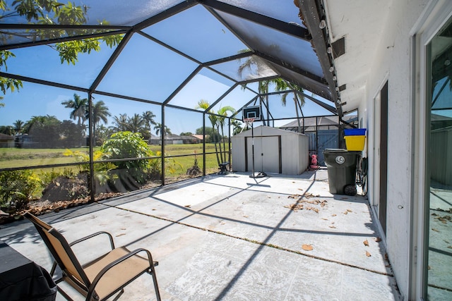 view of patio with a lanai, an outdoor structure, and a shed