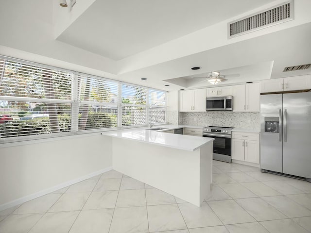 3642 SW Sunset Trace Cir, Palm City, FL 34990 - kitchen featuring visible vents, appliances with stainless steel finishes, a peninsula, white cabinets, and a raised ceiling