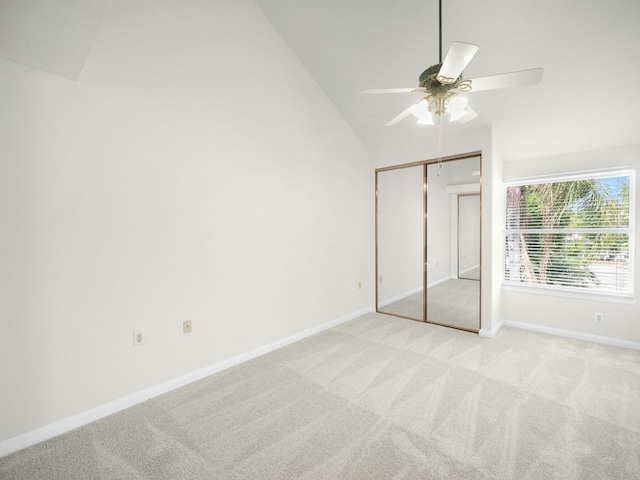3642 SW Sunset Trace Cir, Palm City, FL 34990 - unfurnished bedroom with a ceiling fan, baseboards, high vaulted ceiling, a closet, and light carpet